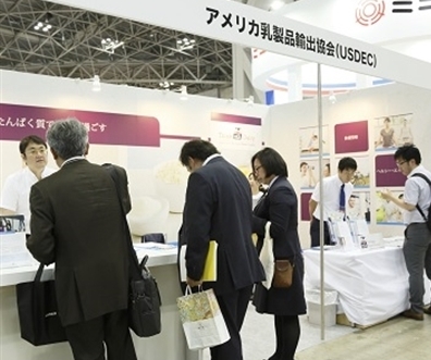 Booth visitors talk to USDEC staff at trade show in Tokyo